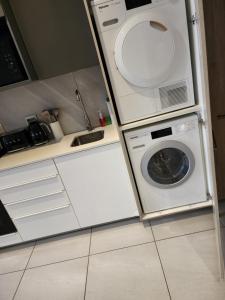 a laundry room with a washer and a washing machine at 10th floor, Unit 1008, in The Capital Trilogy, overlooking Sun Time Square in Pretoria