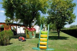 a playground with a slide and a play house at Ferienwohnung in Venedig mit Grill in Tessera