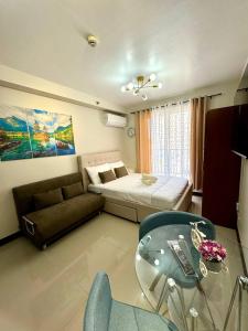 SubaSassy Studio Lapu-Lapu Mactan的客厅配有床和玻璃桌