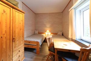 Habitación pequeña con mesa, cama y escritorio. en Walther Sundweg 14, en Heiligenhafen