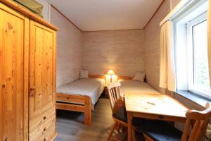 ハイリゲンハーフェンにあるWalther Sundweg 14のテーブル、ベッド、デスクが備わる小さな客室です。