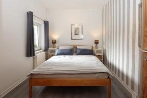 Una cama en una habitación con dos lámparas y una ventana. en Walther Sundweg 14, en Heiligenhafen