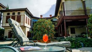 a glass of wine sitting on a table in front of a house at RuinAdalia Hotel - Adult Only in Antalya