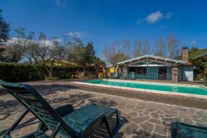 a pool with a chair and a house at Agriturismo Il Poderino in Grosseto