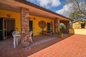 a patio of a yellow house with a table and chairs at Agriturismo Il Poderino in Grosseto