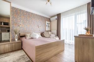 a bedroom with a large bed and a window at Vila Sonata Palanga in Palanga