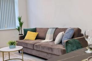 a living room with a brown couch with colorful pillows at Charming 1-Bed Apartment in Leeds in Leeds