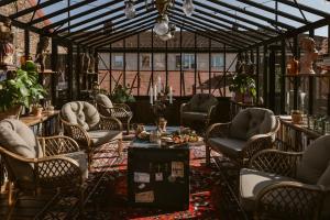 a conservatory with chairs and a table in a room at Hotell Gästis in Varberg