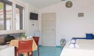 Habitación con mesa, cama, mesa y sillas. en Villa Fontana Limite, en Vietri