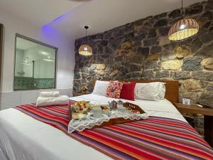 um quarto com uma cama grande e uma parede de pedra em Pousada Santa Fe de Penedo em Penedo