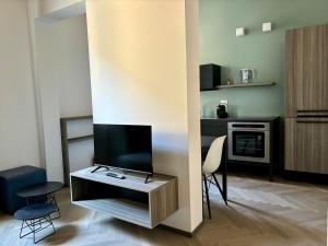 a living room with a tv and a table with chairs at Saragozza Suite 2 Intero appartamento in centro storico WIFI e parcheggio gratuito in Modena +11 photos