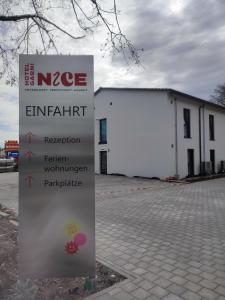 una señal frente a un gran edificio blanco en Hotel Nice garni en Ichenhausen