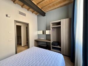 a bedroom with a white bed and a desk at Saragozza Suite 2 Intero appartamento in centro storico WIFI e parcheggio gratuito in Modena