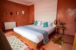 a bedroom with a large bed with red walls at Villa Kamilia Essaouira in Essaouira