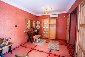 une chambre avec des murs rouges et un chien. dans l'établissement Villa Kamilia Essaouira, à Essaouira