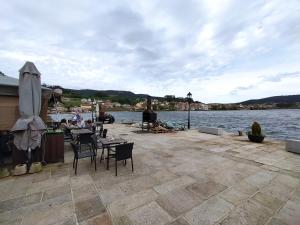 a patio with tables and chairs next to a body of water at Casa Freitas in Combarro