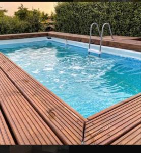 a swimming pool on top of a wooden deck at Natural Oasis Villa in Nea Fokea