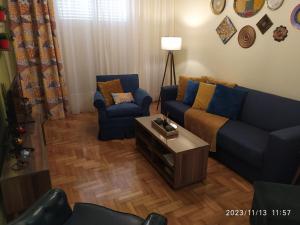 a living room with a blue couch and two chairs at Anna's Flat No2- 2 bedroom apartment in Volos