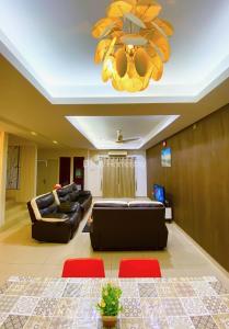 uma sala de estar com um sofá e um lustre em Idaman Bayu Homestay 4 Bedrooms by DKAY in Sendayan em Seremban