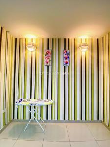 um quarto com uma mesa e uma parede listrada em Idaman Bayu Homestay 4 Bedrooms by DKAY in Sendayan em Seremban