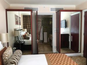 a bedroom with a bed and a large mirror at TAJ Cape Town - Private Luxury One Bedroom Suite in Cape Town