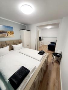 a bedroom with a large bed with white sheets at Pension Apostel in Wismar