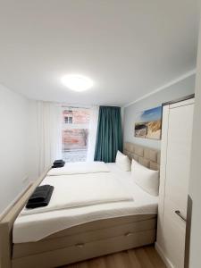 Schlafzimmer mit einem großen weißen Bett und einem Fenster in der Unterkunft Pension Apostel in Wismar