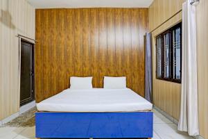 Posto letto in camera con parete in legno. di OYO Hotel The Selaqui Paradise a Jhājra