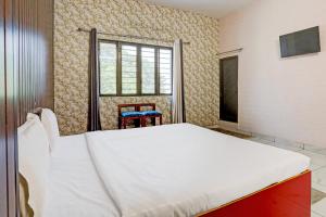 una camera con un grande letto e una finestra di OYO Hotel The Selaqui Paradise a Jhājra
