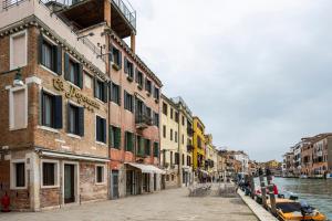 a city street with buildings next to a canal at Hotel Ca' Dogaressa in Venice