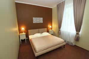 a bedroom with a bed with two tables and a window at RIJA Eiropa Hotel Jurmala in Jūrmala