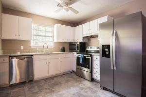 a kitchen with white cabinets and stainless steel appliances at EV-Friendly- 15 Mins to Downtown in Birmingham