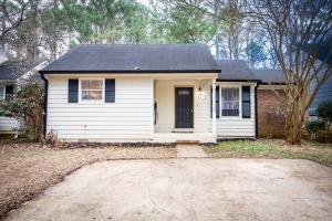 a small white house with a black roof at EV-Friendly- 15 Mins to Downtown in Birmingham