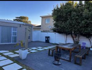 a patio with a wooden table and a tree at DMK GUESTHOUSE 2 in Cape Town