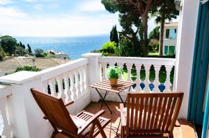 a balcony with chairs and a table and the ocean at El Riu del Cel in Lloret de Mar