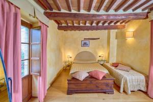a bedroom with two beds and a large window at Borgo Fastelli in Sarteano