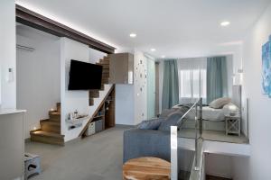 Sala de estar con sofá, cama y TV en Casa Mara 2, en Playa Quemada