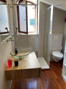 W łazience znajduje się szklana umywalka i toaleta. w obiekcie charmant appartement centre ville w mieście Millau