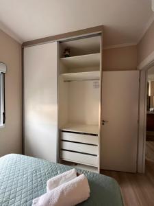 een slaapkamer met een kast en 2 handdoeken bij Apartamento novo e aconchegante! in Mogi-Mirim