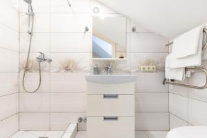 a white bathroom with a shower and a sink at Vila Sonata Palanga in Palanga +60 photos