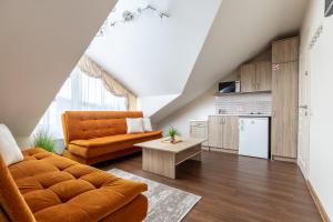 a living room with an orange couch and a table at Vila Sonata Palanga in Palanga