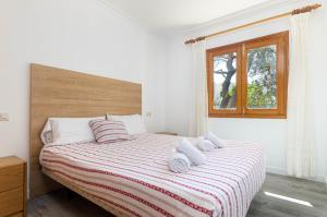 Un dormitorio blanco con una cama con toallas. en YourHouse Villa Canta town house, en Playa de Muro