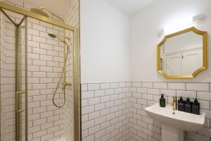 uma casa de banho com um lavatório e um chuveiro com um espelho. em Flower Pot Hotel em Henley on Thames