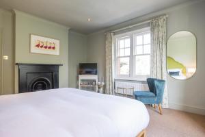 1 dormitorio con 1 cama blanca grande y 1 silla en Flower Pot Hotel en Henley on Thames