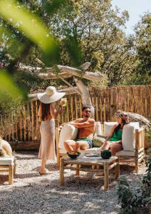 um grupo de pessoas sentadas em cadeiras em um quintal em Residence CASE DI PI GNA, deux magnifiques villas indépendantes avec piscines individuelles , proches de la plage d'Algajola em Algajola