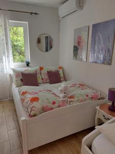 a bedroom with a bed with a floral comforter at Sea Holiday Houses in Drasnice