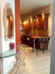 eine Küche mit einem Glastisch und einem Spiegel in der Unterkunft Achilles house in Budapest