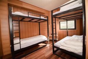 2 łóżka piętrowe w pokoju z drewnianymi ścianami w obiekcie Bungalow1982 w mieście Dồng Văn