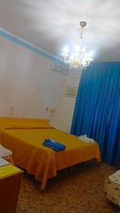 1 dormitorio con cama y cortina azul en B&B Solana, en Noli
