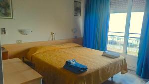 Un dormitorio con una cama con toallas azules. en B&B Solana, en Noli